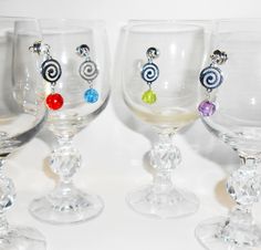 four wine glasses with different colored beads on them