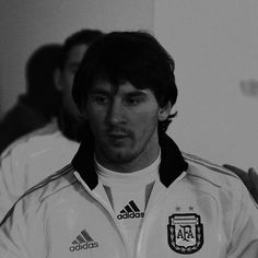 a man standing in front of a group of people wearing adidas jackets and looking at the camera