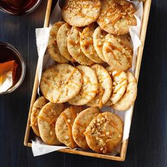 a wooden box filled with cookies and caramel drizzle on top of a table