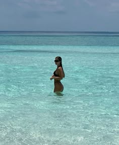 a woman is standing in the ocean water