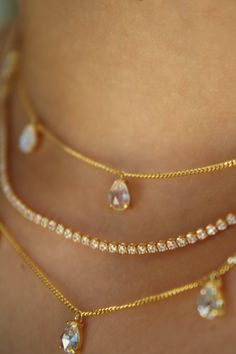 The Dainty Moonstone Drop Choker features five petite, rose cut pear moonstone droplets on a dainty, 14k Gold Vermeil, very high quality curb chain. It features a 3” inch chain extender for layering flexibility. The droplets dangle, and effortlessly add an element of chic sophistication to even your most casual look.  Materials: 14k Gold Vermeil (2.5 microns of gold over a sterling silver base)  Chain Length: 14” + 3” inch chain extender (17” inches total)  Crystal: Genuine Moonstone  How do I c Gold Moonstone Ring, Necklace Stack, Stacked Earrings, Stacked Necklaces, Gold Gemstone Ring, Birthday List, Chain Extenders, Crystal Choker, Tennis Necklace