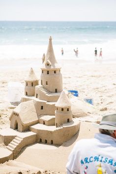 a sand castle on the beach with people in the background