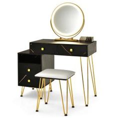 a black vanity with gold legs and a round mirror on the top, next to a stool