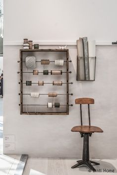 a chair sitting in front of a wall mounted shelf with many different items on it