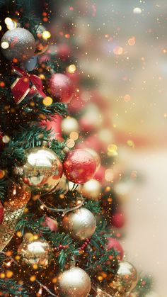 a christmas tree with red and gold ornaments on it, surrounded by snow flakes