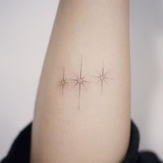 three small stars on the side of a woman's arm