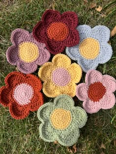 six crocheted flower coasters on the grass