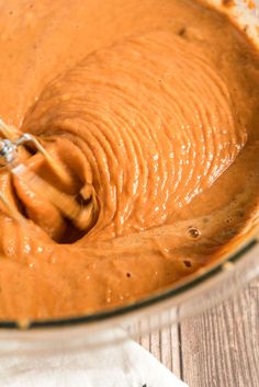 a whisk in a glass bowl filled with peanut butter