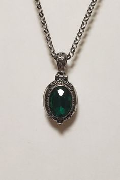 Lovely Victorian Necklace w/green rhinestone,  with Stainless Steel ROLO Chain.              Victorian Locket Setting, Oval, Antique Silver -  Stainless steel, 25mm (1 inch) tall 16mm  (5/8 inch) wide. Oval Dark Green Glass Crystal Rhinestone,  14mm X 10mm (9/16 inch) tall X (3/8 inch) wide 20 inch Stainless Steel ROLO Chain, 2.5mm - 1/8 dia.   Bail Connector              Plus a Free Pair of Dark Green -            Crystal Glass Teardrop Earrings.         Lead, Nickle, Cadmium Free Metal Alloy Oval Green Jeweled Jewelry, Dark Green Necklace, Emerald Locket, Victorian Green Metal Jewelry, Ornate Green Oval Necklaces, Luxury Green Victorian Necklaces, Victorian Green Pendant Jewelry, Green Gothic Necklace, Emerald Green Necklace