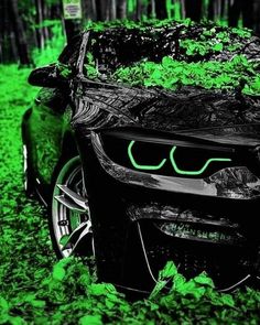 a car that is sitting in the grass with green lights on it's hood