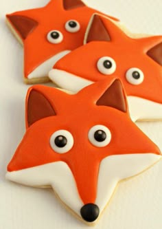 three decorated cookies with eyes on top of each other and one has a fox face