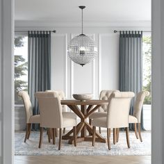 a dining room table with beige chairs and a chandelier hanging from the ceiling