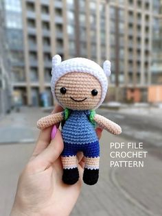 a hand holding a small crocheted doll