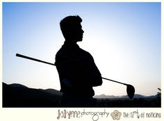 the silhouette of a man holding a golf club in front of a blue sky and mountains