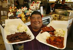 a man holding two trays of food in front of him