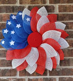 a red, white and blue wreath on a brick wall