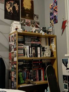 a skateboard is sitting in front of a bookshelf filled with movies and posters