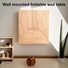 a wall mounted foldable wall panel table next to a potted succulent plant