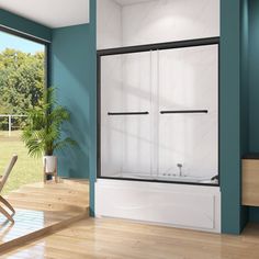 a bathroom with blue walls and wood flooring next to a sliding glass shower door