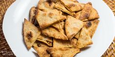 a white plate topped with tortilla chips on top of a woven table cloth