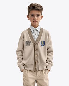 a young boy standing in front of a white background wearing a cardigan and khaki pants