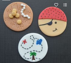 three decorated cookies on a table with one pirate and the other is made to look like bread