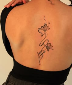 the back of a woman's shoulder with flowers and vines on her left side