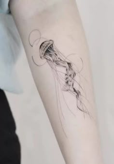 a woman's arm with a jellyfish tattoo on it