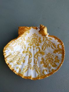 a decorative gold and white plate hanging on the wall