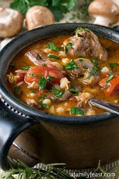 a close up of a bowl of soup with mushrooms and carrots in the background