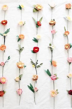 paper flowers are arranged on a white surface