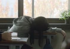 a person sitting at a desk with their head on the back of another person's shoulder