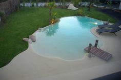 an empty swimming pool in the middle of a yard with lounge chairs and lawn furniture