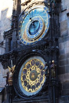 an ornate clock with roman numerals on the side of a stone building in europe