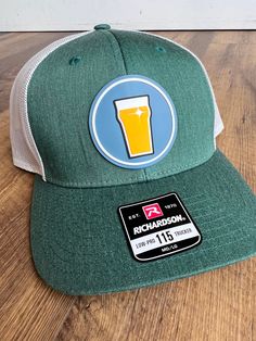 For better pricing and faster turnaround times please consider purchasing this product on our main website at www.luckycrowhatcompany.com or email us directly at Danielle@LuckyCrowHatCompany.com Elevate your beer-drinking experience with our meticulously curated Richardson 115 cap in Heather Green with Silver Mesh, paired flawlessly with a sharp PVC patch depicting a classic beer pint glass. This hat color combination has been handpicked by our color experts to ensure the perfect harmony between Beer Hat, Beer Drinking, Pvc Patches, Heather Green, Perfect Harmony, Beer Lovers, Profile Design, Drinking Beer, Hat Making