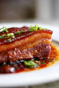 a white plate topped with meat covered in sauce