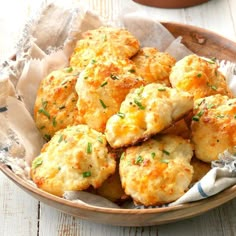 a bowl filled with cheesy biscuits on top of a table