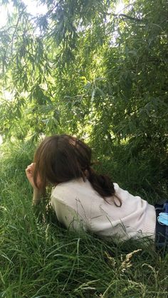 a woman laying on the ground in tall grass