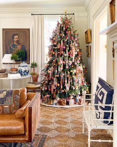 a living room with a christmas tree decorated in ribbons and ornaments on the wall,