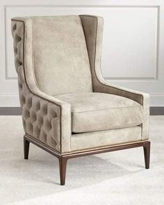 a beige chair sitting on top of a white carpet