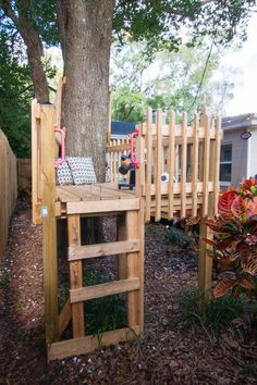 a tree stand made out of wooden pallets in the yard next to a fence