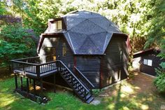 a round house with stairs leading up to the roof and second story in the background