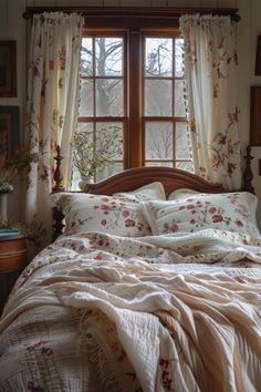 a bed sitting under a window next to a wooden headboard with pillows on top of it