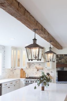 a kitchen with two lights hanging from the ceiling and an island in front of it