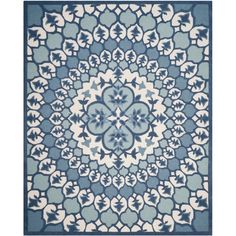 a blue and white rug with an intricate design on the center, in front of a white background