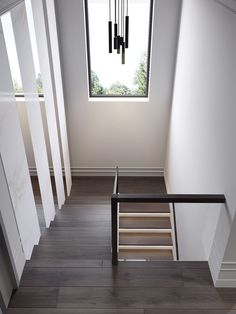 an empty room with stairs leading up to the ceiling and windows above it, in front of a wooden floor