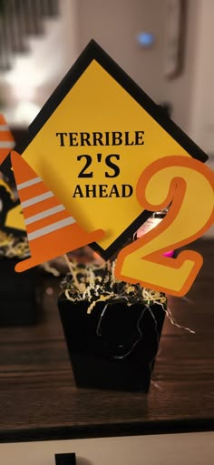 there is a sign that says terrible 2's ahead on the side of a table