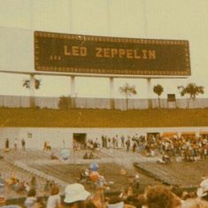 a large sign that reads led zeppelin in front of a crowd of people