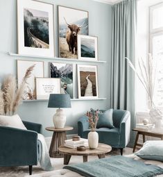 a living room filled with blue furniture and pictures on the wall above it's windows