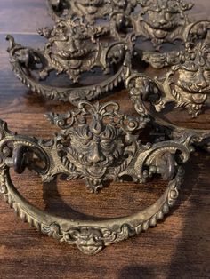 three ornate metal handles on a wooden table